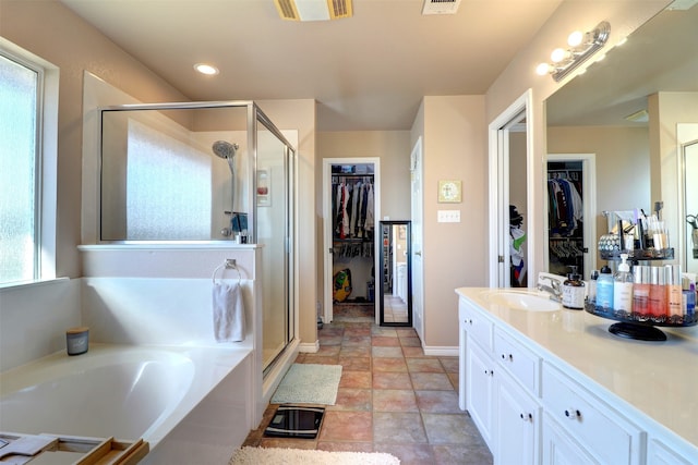 bathroom featuring plus walk in shower, tile patterned floors, and vanity