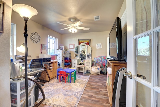 rec room featuring dark wood-type flooring, french doors, a textured ceiling, and ceiling fan