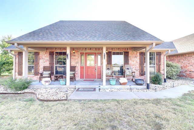 rear view of property with a porch and a lawn