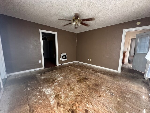 unfurnished room with heating unit, ceiling fan, and a textured ceiling