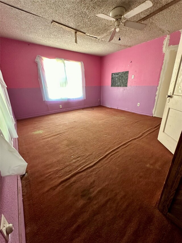 unfurnished bedroom featuring carpet, ceiling fan, and a textured ceiling