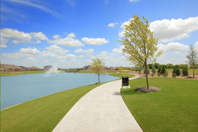 view of home's community with a lawn and a water view