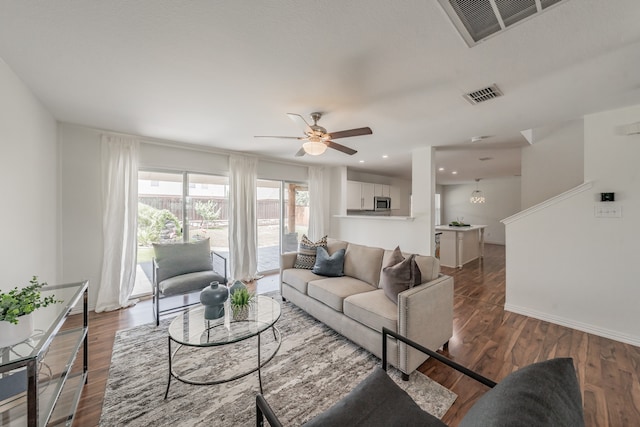 living room featuring dark hardwood / wood-style floors and ceiling fan