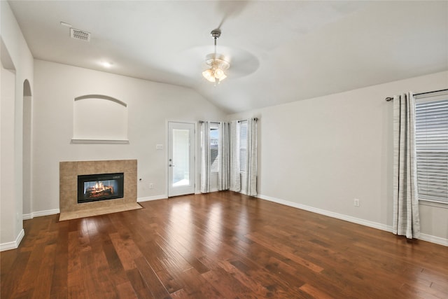 unfurnished living room with vaulted ceiling, ceiling fan, a tile fireplace, and dark hardwood / wood-style flooring