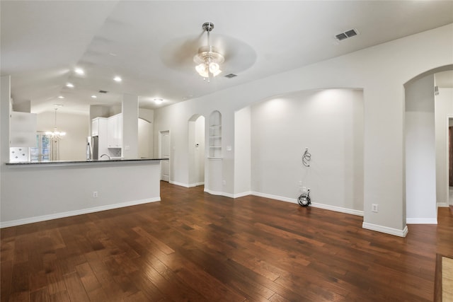 unfurnished living room with dark hardwood / wood-style floors and ceiling fan with notable chandelier