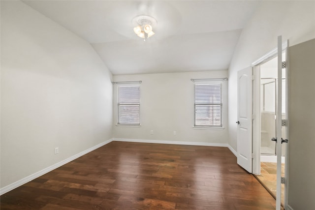 unfurnished room featuring dark wood-type flooring and vaulted ceiling