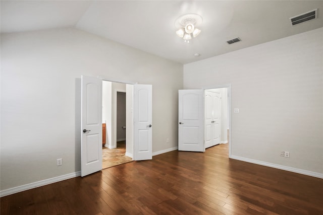 unfurnished bedroom with lofted ceiling and dark hardwood / wood-style flooring