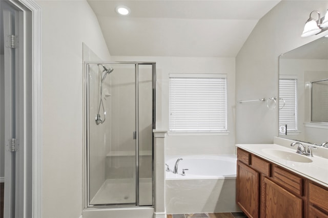 bathroom featuring vanity, shower with separate bathtub, and vaulted ceiling