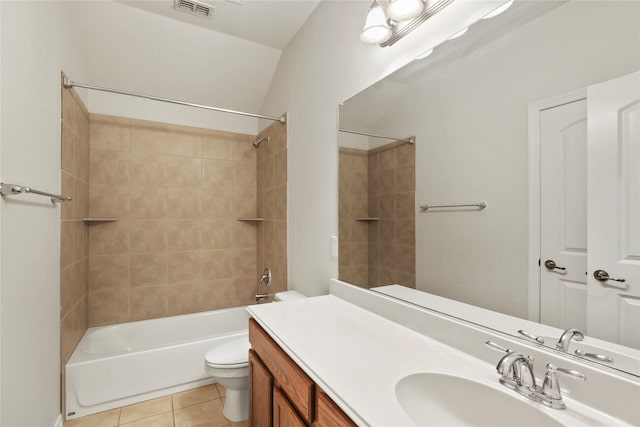 full bathroom featuring lofted ceiling, tiled shower / bath, toilet, vanity, and tile patterned floors