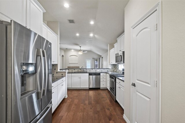 kitchen with tasteful backsplash, sink, white cabinetry, stainless steel appliances, and lofted ceiling