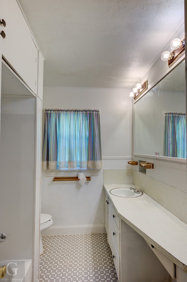 bathroom featuring tile patterned flooring, a textured ceiling, vanity, and toilet