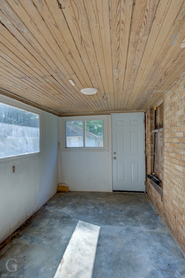 basement featuring wood ceiling and brick wall