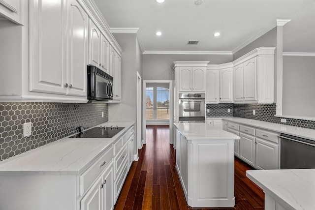 kitchen with ornamental molding, appliances with stainless steel finishes, white cabinetry, and dark hardwood / wood-style floors