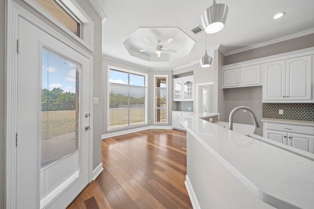 kitchen with decorative light fixtures, tasteful backsplash, white cabinetry, hardwood / wood-style flooring, and ceiling fan