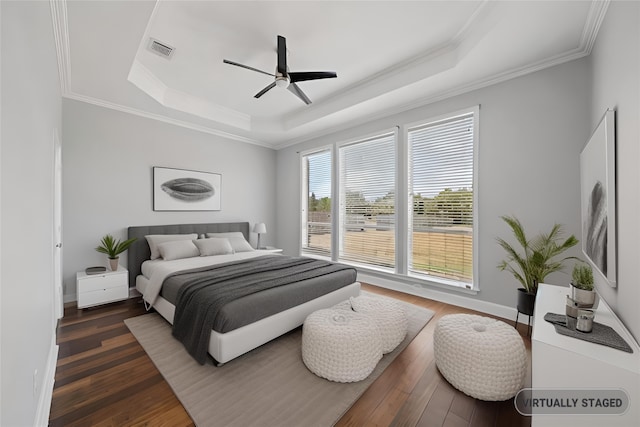 bedroom with a raised ceiling, ceiling fan, and dark hardwood / wood-style floors