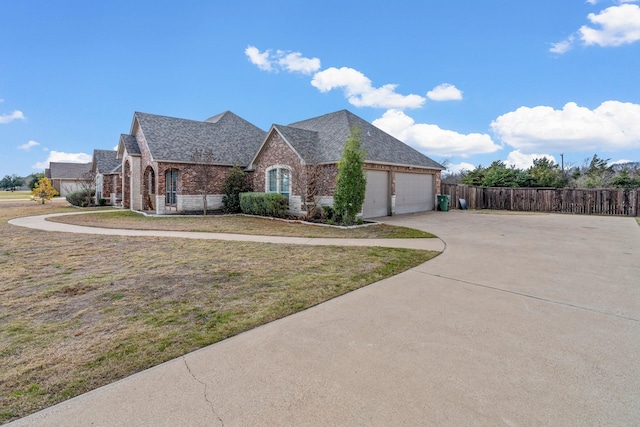 view of home's exterior with driveway, a garage, fence, a yard, and brick siding