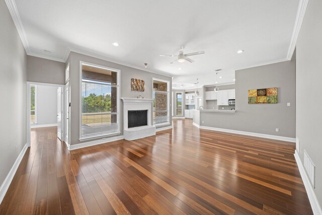 unfurnished living room featuring crown molding, ceiling fan, and wood-type flooring