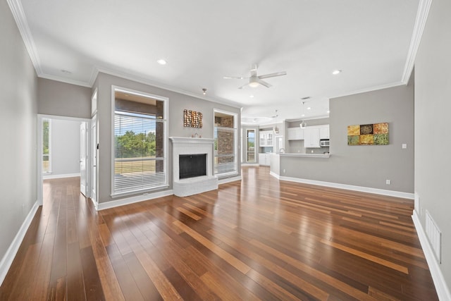 unfurnished living room with a brick fireplace, baseboards, and dark wood finished floors