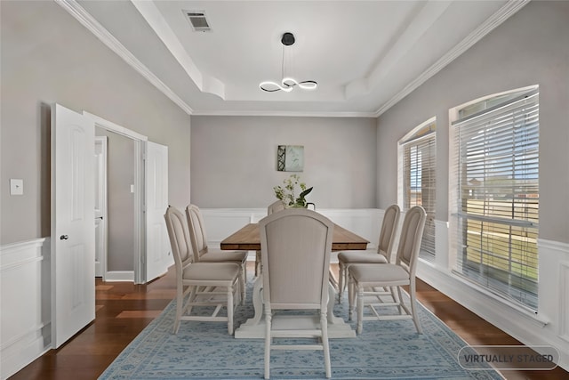 dining space featuring ornamental molding, a raised ceiling, and dark hardwood / wood-style floors