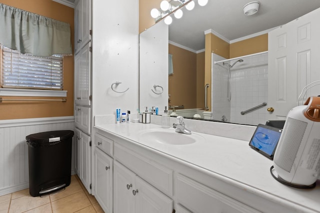 bathroom with ornamental molding, wainscoting, vanity, tile patterned flooring, and tiled shower