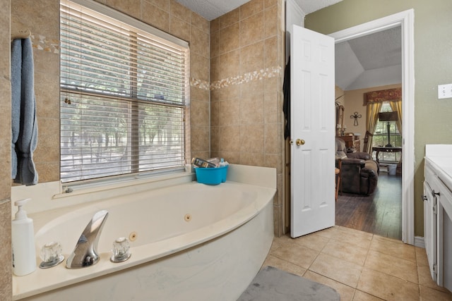 bathroom featuring tile patterned flooring, a textured ceiling, vanity, and tile walls