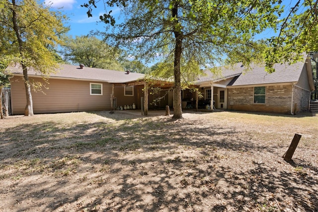 rear view of house with fence and brick siding