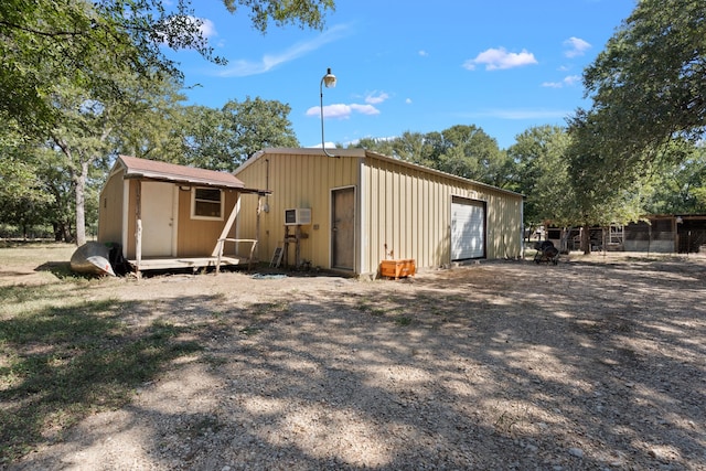 back of property with an outdoor structure and a garage