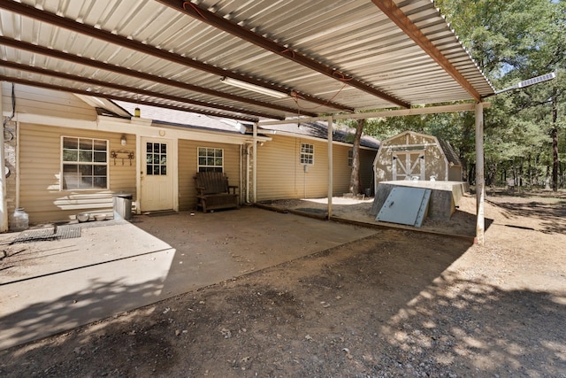 view of patio / terrace featuring a storage shed, a pergola, a carport, and an outbuilding