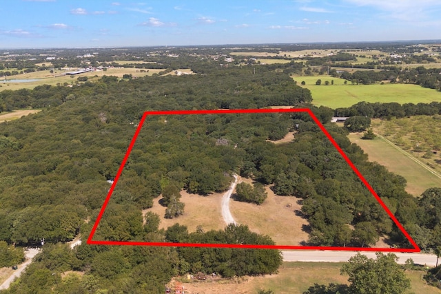 bird's eye view featuring a view of trees and a rural view