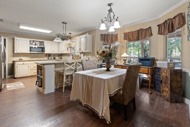 dining room featuring crown molding, a chandelier, and hardwood / wood-style flooring