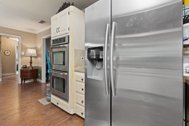 kitchen with decorative backsplash, dark wood-type flooring, light stone countertops, crown molding, and stainless steel appliances