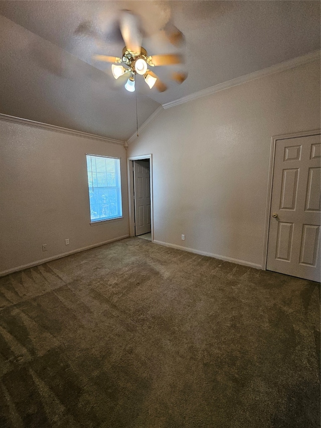 empty room featuring ornamental molding, vaulted ceiling, ceiling fan, a textured ceiling, and dark colored carpet