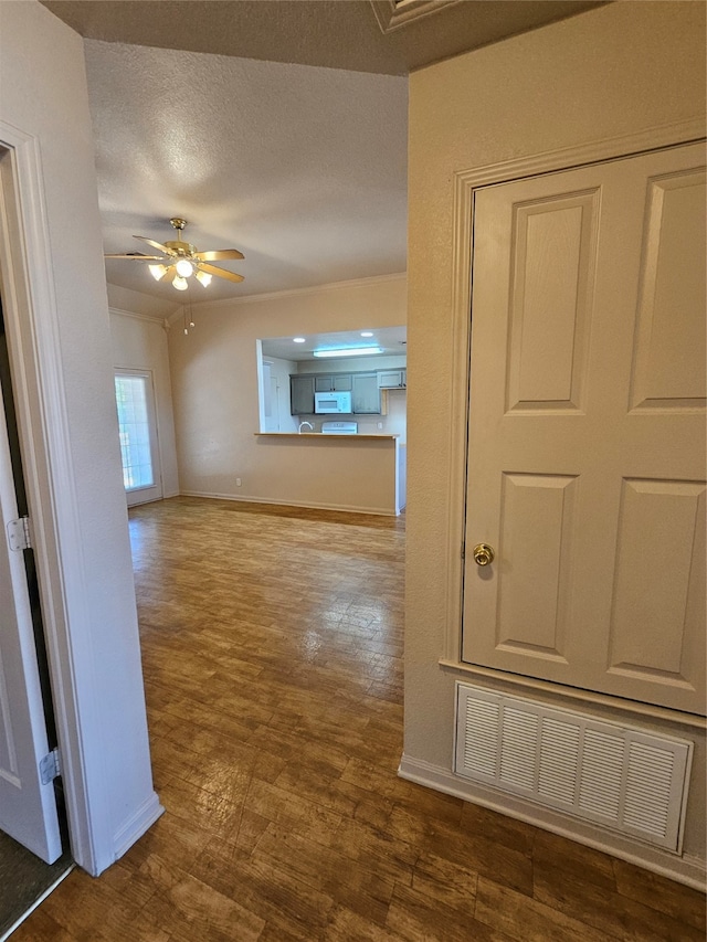 corridor featuring a textured ceiling and wood-type flooring