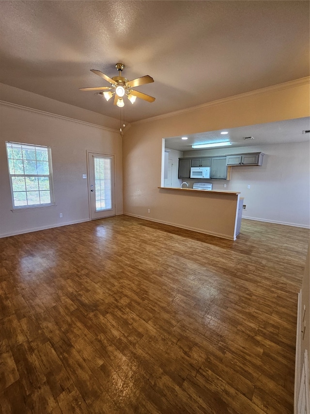 unfurnished living room with ceiling fan, dark hardwood / wood-style floors, and crown molding