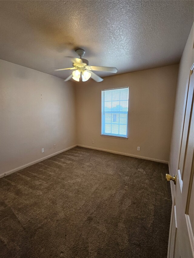 unfurnished room featuring ceiling fan, dark carpet, and a textured ceiling