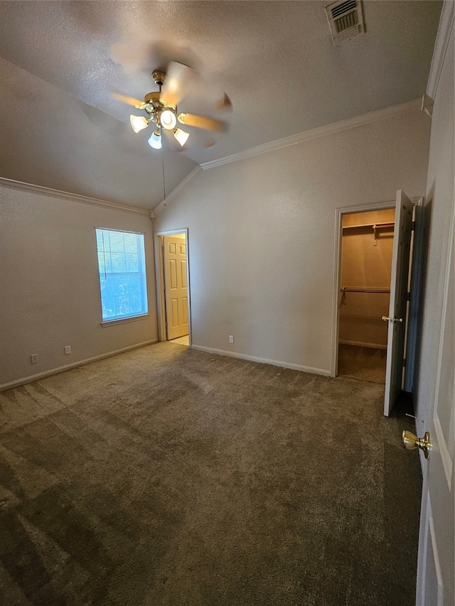 unfurnished bedroom featuring ceiling fan, carpet, crown molding, and lofted ceiling