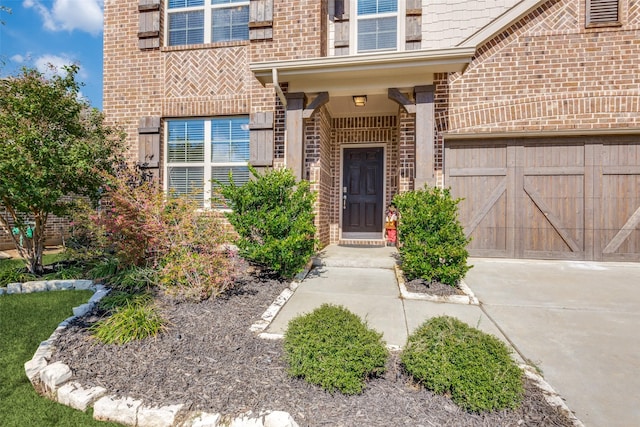 entrance to property featuring concrete driveway and brick siding