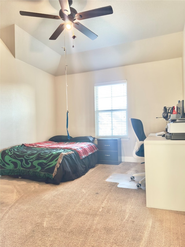 bedroom with ceiling fan, vaulted ceiling, and carpet floors