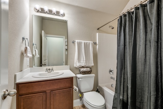 bathroom with a textured wall, vanity, shower / bath combo with shower curtain, and toilet