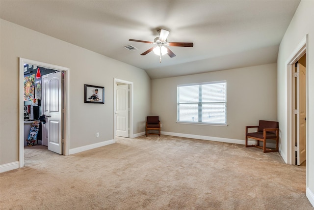 unfurnished bedroom with lofted ceiling, a spacious closet, visible vents, and light colored carpet