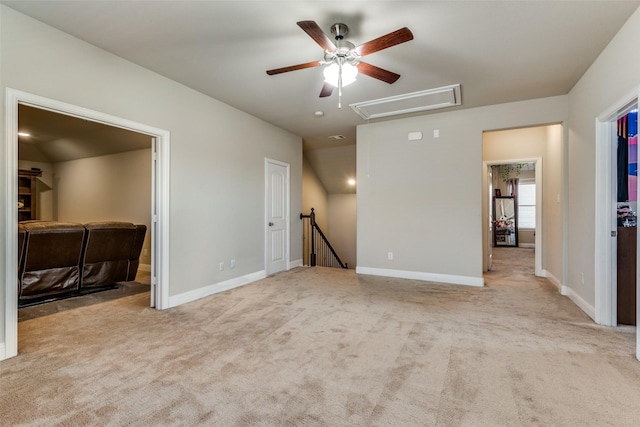 carpeted spare room featuring attic access and baseboards