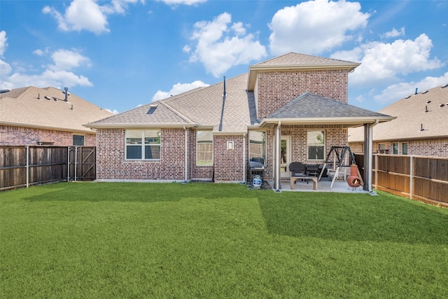 back of house with a shingled roof, a patio area, brick siding, and a fenced backyard