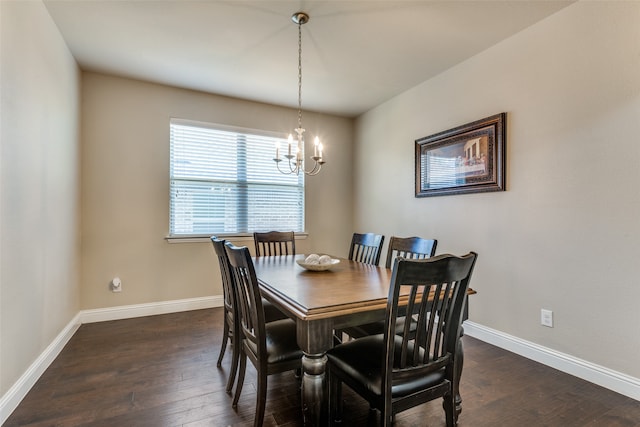 dining space with dark hardwood / wood-style flooring and an inviting chandelier