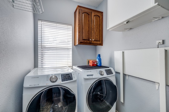 washroom featuring washing machine and dryer, plenty of natural light, and cabinets