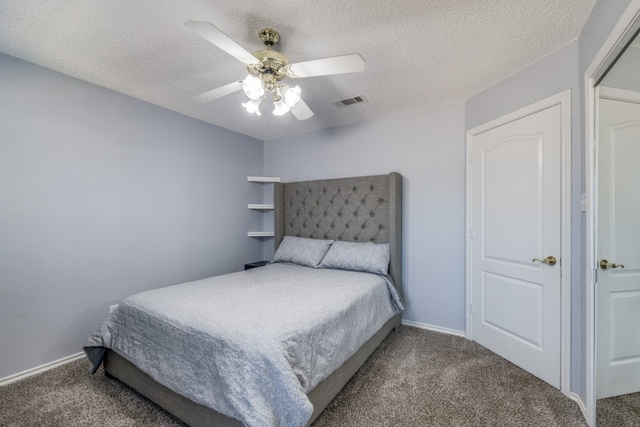 carpeted bedroom featuring ceiling fan and a textured ceiling