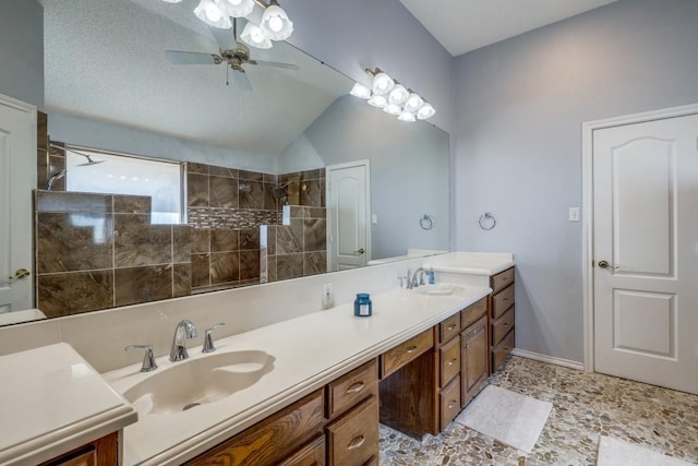 bathroom featuring a tile shower, ceiling fan, a textured ceiling, vaulted ceiling, and vanity