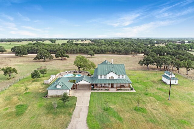 rear view of property with a garage, central AC unit, a lawn, and a porch