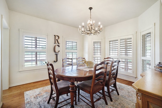 dining area featuring a notable chandelier, a wealth of natural light, and wood-type flooring