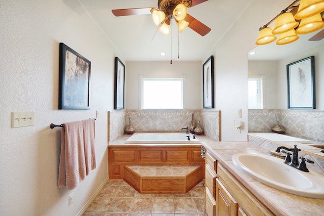 bathroom with a healthy amount of sunlight, vanity, tile patterned flooring, and a bathing tub