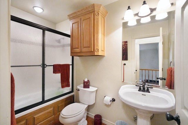 full bathroom with sink, shower / bath combination with glass door, and toilet